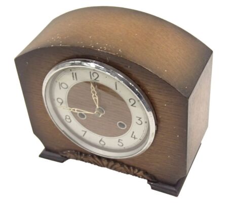 A 1950s Bentima oak cased mantel clock, the arch top with floral scroll dial, silvered numeric chapter ring, 22cm high, 23cm wide, 11cm deep.