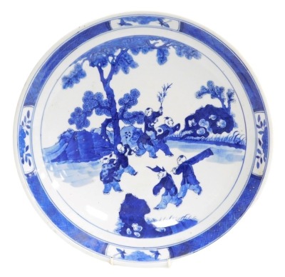 A 19thC Qing dynasty Chinese porcelain charger, decorated in blue and white with various figures in a landscape and a diaper work border, six character Kangxi mark to base, in underglaze blue, 37cm diameter. (AF)