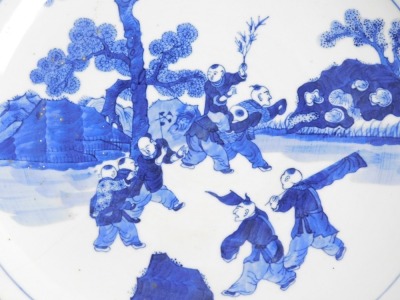 A 19thC Qing dynasty Chinese porcelain charger, decorated in blue and white with various figures in a landscape and a diaper work border, six character Kangxi mark to base, in underglaze blue, 37cm diameter. (AF) - 2