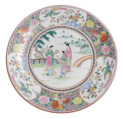 A 20thC Chinese porcelain charger, decorated in coloured enamels, having figures in the central landscape and enclosed by a deep border of butterflies, peonies, fruit and birds, marked with an impressed two character seal highlighted in underglaze red, 46