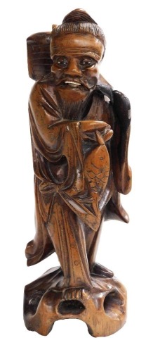 A 19thC Qing dynasty Chinese hardwood carving of a fisherman with his catch, with silver wire inlays, bone inlaid teeth, 30cm high.