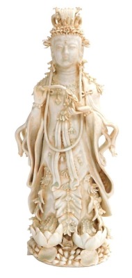 A 20thC Chinese porcelain figure of Guanyin standing on a lotus base, with a matte orange residue to the crevices, 31cm high.