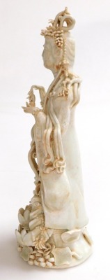 A 20thC Chinese porcelain figure of Guanyin standing on a lotus base, with a matte orange residue to the crevices, 31cm high. - 2