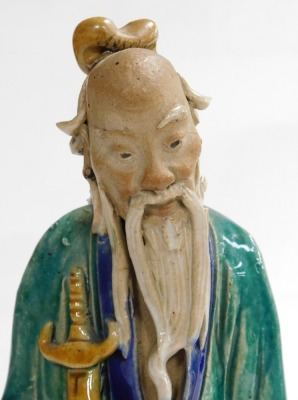 A 19th/20thC Chinese part glazed ceramic figure of a sage, in green, blue and yellow; holding a sheathed sword, 31cm high. - 5