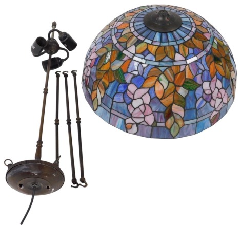 A Tiffany style glass ceiling light, with a triple lamp fitting, the shade decorated with flowers and leaves, 49cm wide.