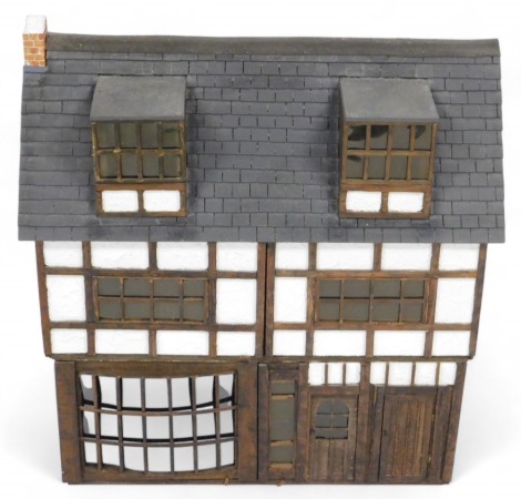 A Tudor style doll's house, of three floors, with five rooms, 68cm x 69cm, together with assorted doll's house furniture and dolls.