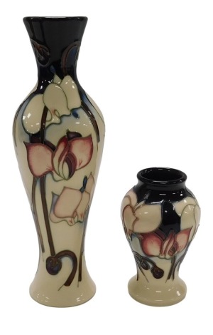 A Moorcroft pottery Cyclamen pattern vase, designed by Emma Bossons, impressed and painted marks, boxed, 21cm high, and a smaller Cyclamen pattern vase, boxed, 10cm high. (2)