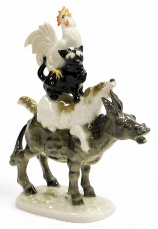 A Hutchenreuther porcelain animal figure group, of a cockerel atop a cat atop a dog atop a donkey, raised on an oval base, printed marks, 19cm high.