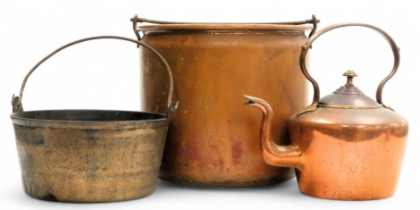 An early 20thC copper log bucket, with cast iron swing handles, 28cm high, jam pan, and a copper kettle. (3)