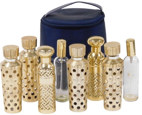 A group of Guerlain refillable perfume bottles, comprising four of cylindrical tapering design with pierced and impressed roundel decoration, 17cm high, two further bottles of lattice work decoration, etc.