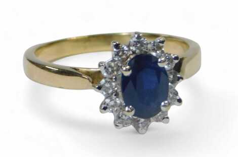 An 18ct gold sapphire and diamond cluster ring, the central oval cut sapphire surrounded by tiny diamonds, each claw set,