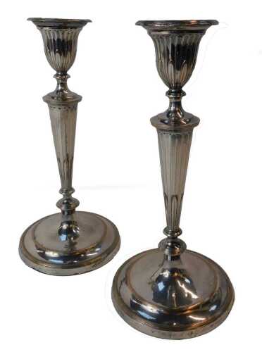 A pair of 19thC silver plated candlesticks, each of fluted tapering form on a circular outswept base, 27cm high.