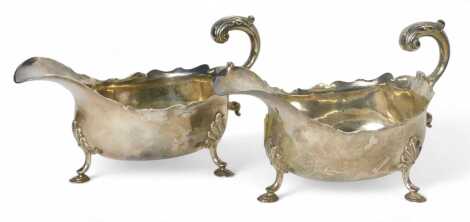 A pair of George II silver sauce boats, with leaf capped scroll handle, on three hoof feet, London 1758, 16.93oz.