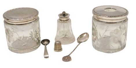 A small group of cut glass and silver wares, comprising two silver topped dressing table jars, a silver plated salt spoon, silver thimble, silver teaspoon with tennis mounted top, and a silver topped perfume bottle, 1.37oz. (6)