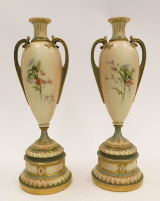 A pair of Royal Worcester blush ivory ground two handled vases, painted with flowers, on a tapering stem and domed foot, printed marks in puce to underside, registration number 304838 above 1957, 27cm high. - 2