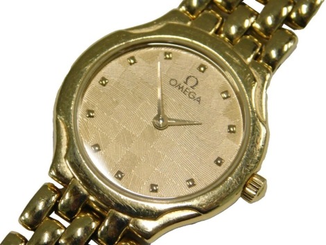 An Omega lady's 18ct gold cased wristwatch, circular dial in a chequer board design, on an 18ct gold bracelet strap, 45.1g all in.