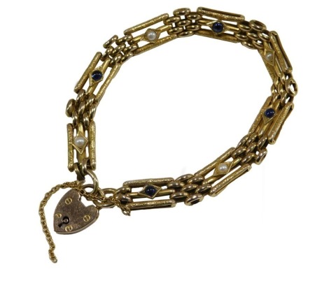 A 9ct gold cabochon sapphire and seed pearl gate bracelet, with a textured finish, on a heart shaped padlock clasp, with safety chain as fitted, 16g.