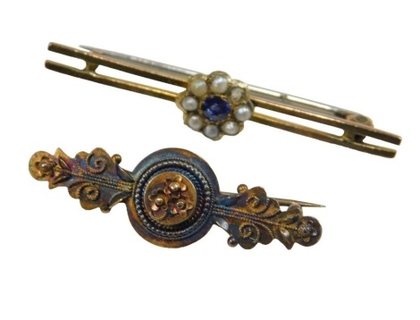 A late 19thC sapphire and seed pearl floral bar brooch, one pearl lacking, yellow metal, unmarked, 2.1g, together with a Victorian Etruscan style brooch, stamped 15ct, 2.4g.