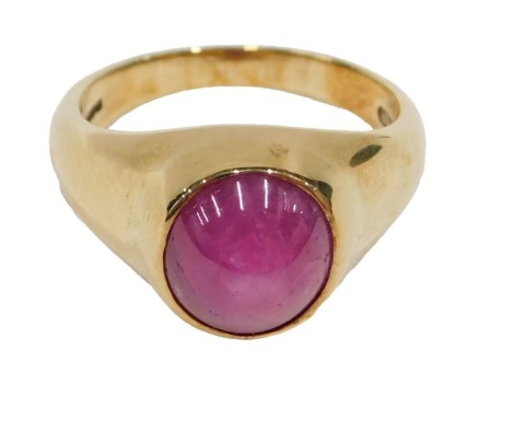 An 18ct gold star ruby 20thC dress ring, the single cabochon cut oval stone, 10mm x 8.5mm x .2mm, approx 6.59ct, in a rub over setting, on plain yellow meal band, London 1996, ring size O, 10g all in.