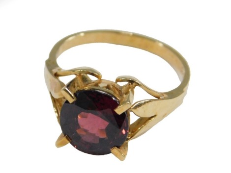 A 20thC garnet single stone dress ring, set with circular faceted cut deep ruby garnet, 9.6mm x 9.6mm x 6mm, approx 4.48ct, on a yellow metal band stamped 18ct, ring size P, 5.2g all in.