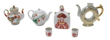 A collection of Lomonosov teapots, a decanter and stopper, and two small cups, decorated with a female figure holding a bird. (6)