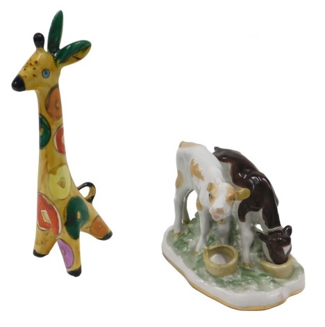 A Russian Konakova studio ware giraffe, with multicoloured spots, 25cm high, and a Verbilki porcelain cow group, 14cm wide.