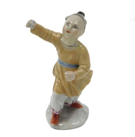 A Russian Popov porcelain figure of a young girl, wearing a beige jacket and red shoes, on ovoid base, indistinct impress marks, 12cm high. (AF)