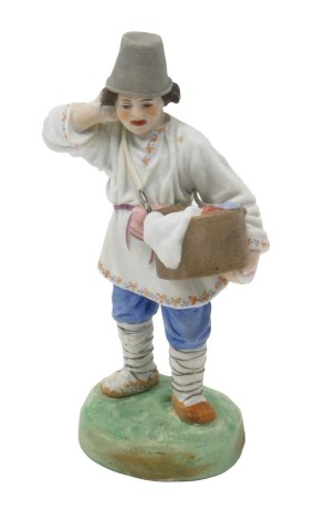 A small 19thC Russian Gardner bisque porcelain figure, of a young man wearing a grey hat, holding a basket of washing, on a ovoid base, printed marks in red to underside and impressed marks, 13cm high. (AF)