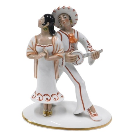 A mid to late 20thC Spanish porcelain figure group, modelled in the form of a musician and a lady, picked out in iron red, on an oval base, printed mark to underside, 30cm high. (AF)