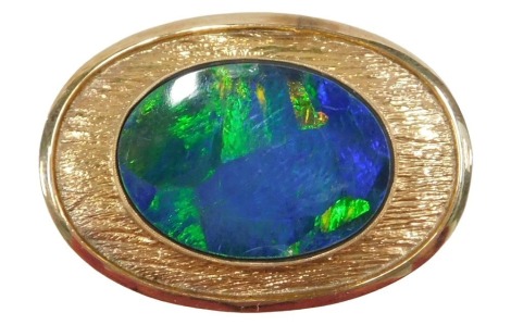 A 20thC opal doublet pendant, the oval doublet 21mm x 14mm, in an abstract bark effect rub over oval frame, yellow metal stamped 10k, 3cm x 2cm, 6.1g all in.