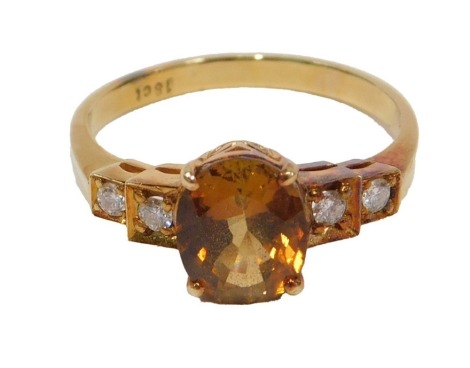 A 20thC topaz and diamond dress ring, set with central oval cut topaz, 8.5mm x 7mm x 5.21mm, approx 2.31ct, claw set, flanked by four round brilliant cut diamonds, each approx 0.03ct, grain set, on a plain yellow metal band stamped 18ct, ring size P½, 3.8