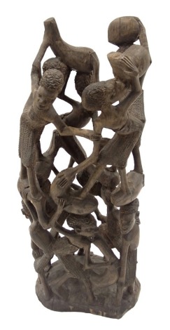 Tribal Art. A carved figure group of men and women carrying water vessels, 41cm high.