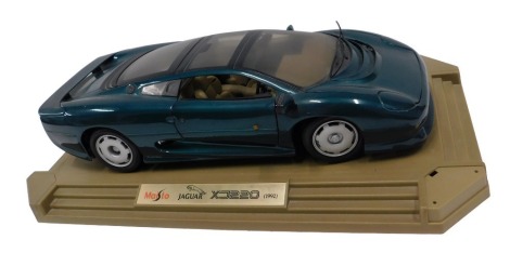 A Maisto model of a Jaguar XJ220, from 1992, on a stepped plinth, 47cm wide.