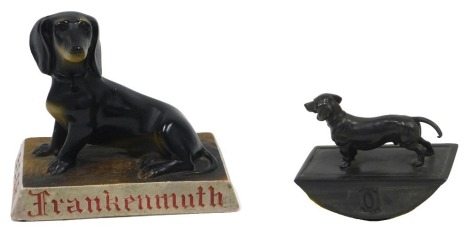 A Chalkware advertising figure for Frankennuth ale, decorated with a dachshund, 18cm wide, and a bronze effect spelter blotter mounted with a figure of a dachschund. (2)