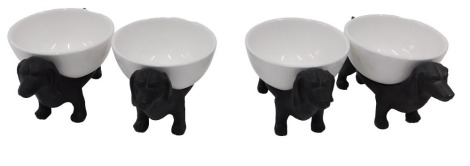 A set of four bronze effect resin stands, each modelled in the form of a dachshund, mounted with a white bowl.