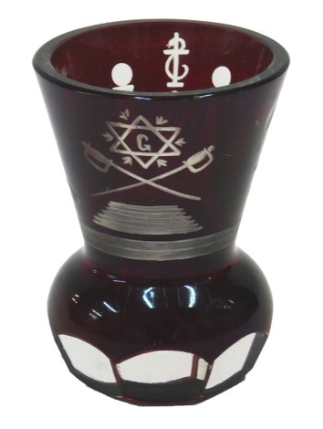 A Bohemian masonic ruby flash shooting glass, decorated with various symbols to include cross swords, star, sun, etc., 9cm high.