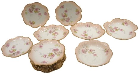 A Limoges French porcelain part dessert service, comprising bowl, oval serving plate, two serving bowls, and ten dinner plates.