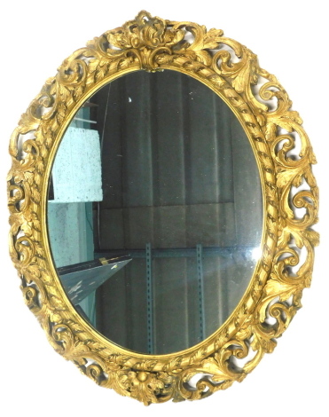 A 19thC gilt gesso oval wall mirror, the frame elaborately decorated with pierced scrolling leaves, etc., 83cm x 70cm. (AF)