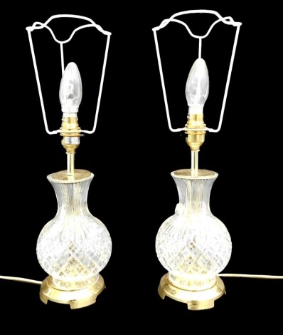 A pair of cut glass and gilt brass table lamps, 38cm high to top of bulb.