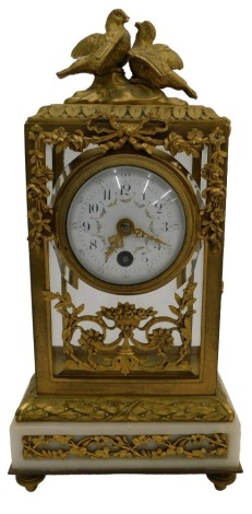 A late 19thC French ormolu and white onyx mantel timepiece, the four glass case decorated with a crest of birds, above a white enamel dial decorated with floral swags, unsigned, 27cm high.