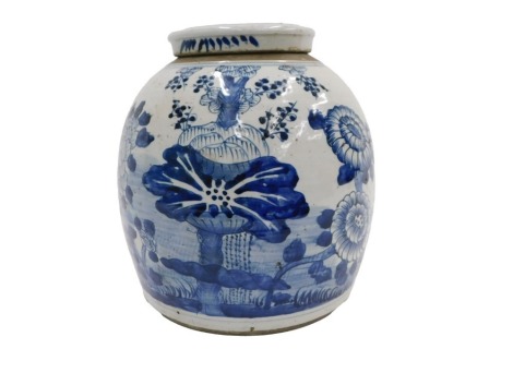 A late 18th/early 19thC Chinese provincial ginger jar, decorated with blue with flowers, etc., and an associated lid, 30cm high overall.