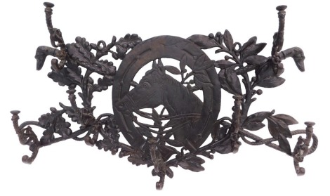 A cast iron coat rack, decorated centrally with a horse's head in profile, flanked by seven scroll cast hooks, decorated overall with Greyhounds, leaves, acorns, whips, etc. 76cm wide.