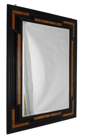 A Dutch style ebonised and simulated burr wood mirror, with ripple and raised moulded frame, 118cm high, 87cm wide.