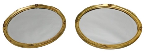 A pair of oval gilt wall mirrors, 46cm x 57cm.