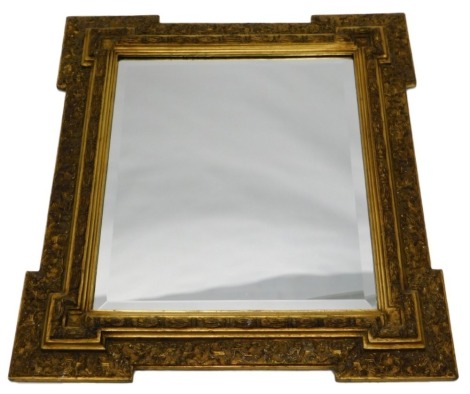 A gilt wall mirror, with elaborate moulded frame, surrounding a rectangular bevelled plate, 86cm high, 74cm wide.