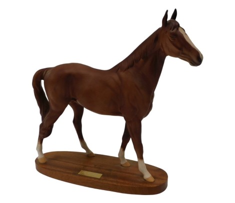 A Beswick matte glazed racehorse The Minstrel, on a mahogany base, 34cm long.