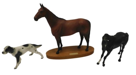 A Royal Doulton matte glazed figure Arkle, on a mahogany base, 33cm long, a Beswick matte glazed black horse (AF), and a ceramic setter. (3)