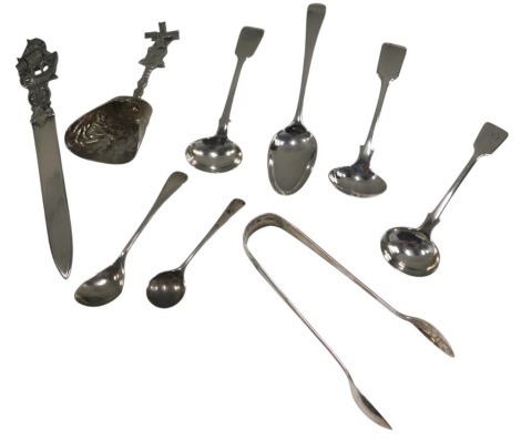 A collection of white metal and silver spoons, etc., to include a Dutch caddy spoon with windmill handle, sugar tongs, etc., weighable items 3.15oz, and a Continental silver coloured metal paper knife, the handle cast as a galleon.