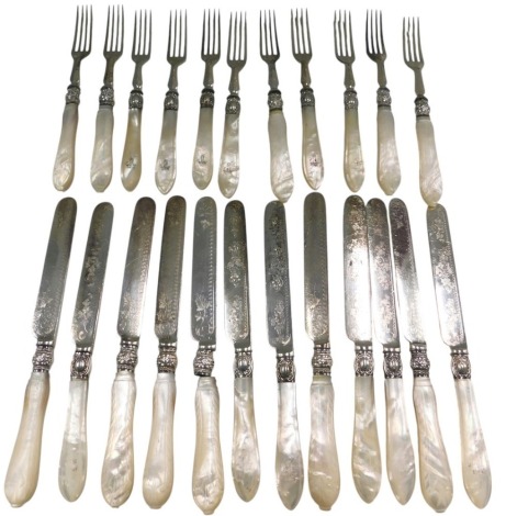 An associated part set of dessert knives and forks, each with engraved blades and mother of pearl handles, some crested.