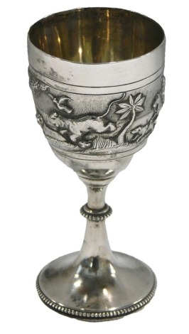 A silver coloured metal small goblet, embossed with elephants, palm trees, etc., and engraved Laurence, 8.5cm high.